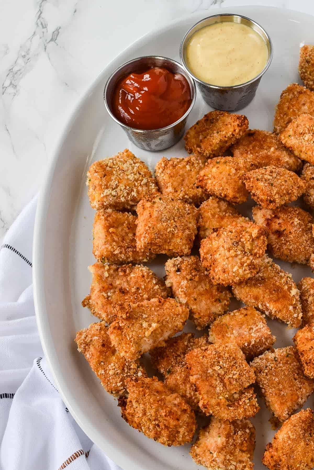 Homemade Baked Chicken Nuggets on a white serving plate.