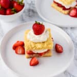 Easy Strawberry Shortcake on a plate with strawberries and extra whipped cream.