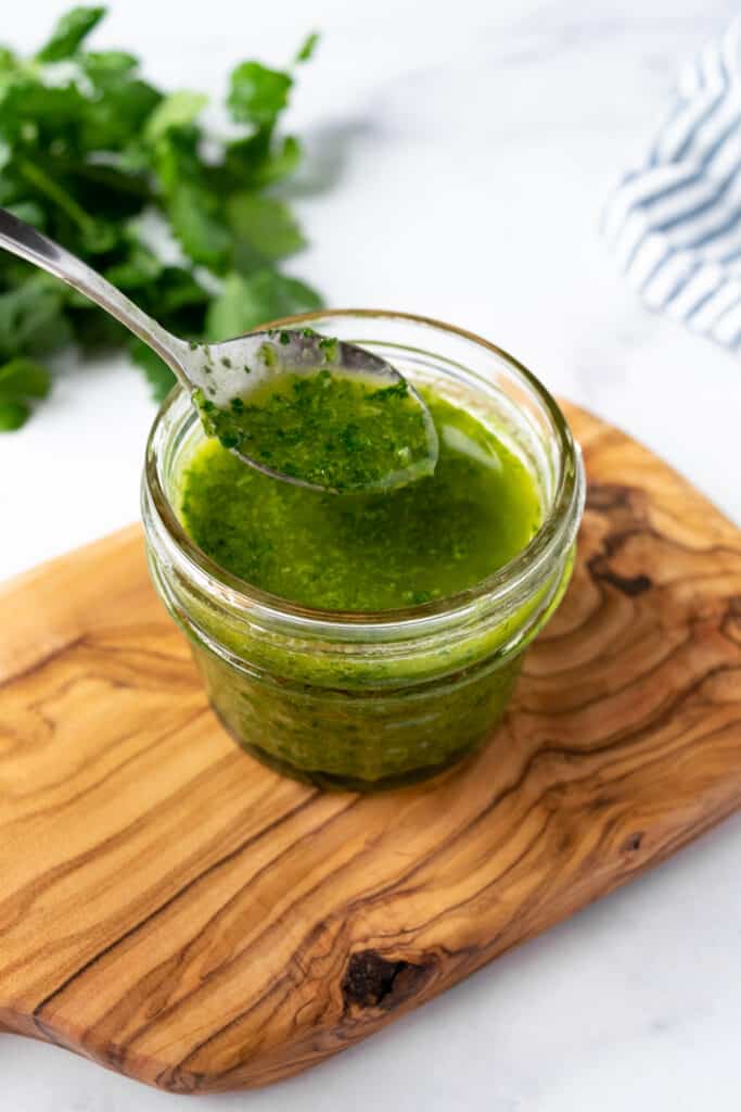 Cilantro Lime Vinaigrette in a small jar with a spoon.