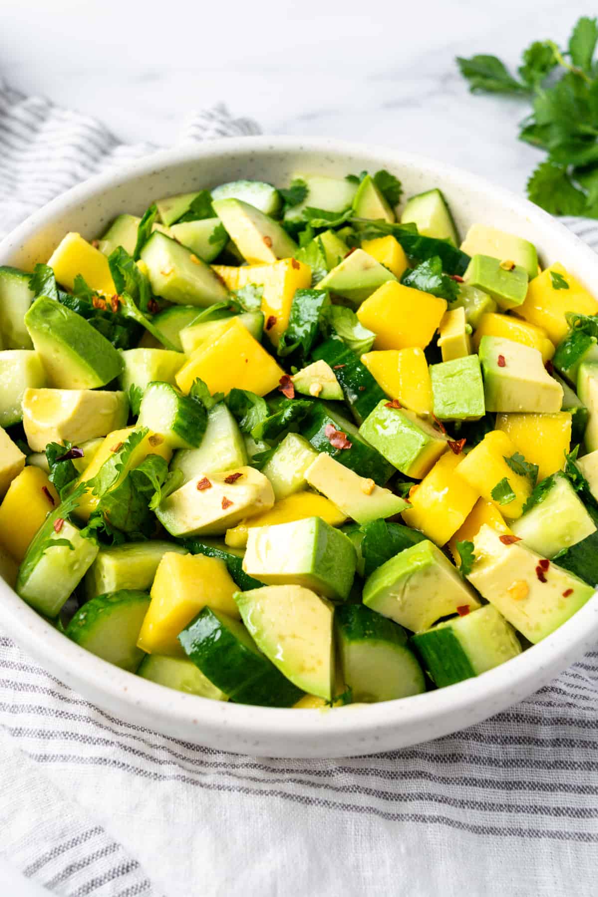 Cucumber Mango Salad with Avocado in a white bowl
