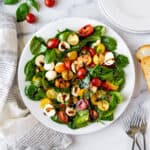 Spinach Caprese Salad on a white plate.