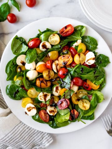Spinach Caprese Salad on a white plate.