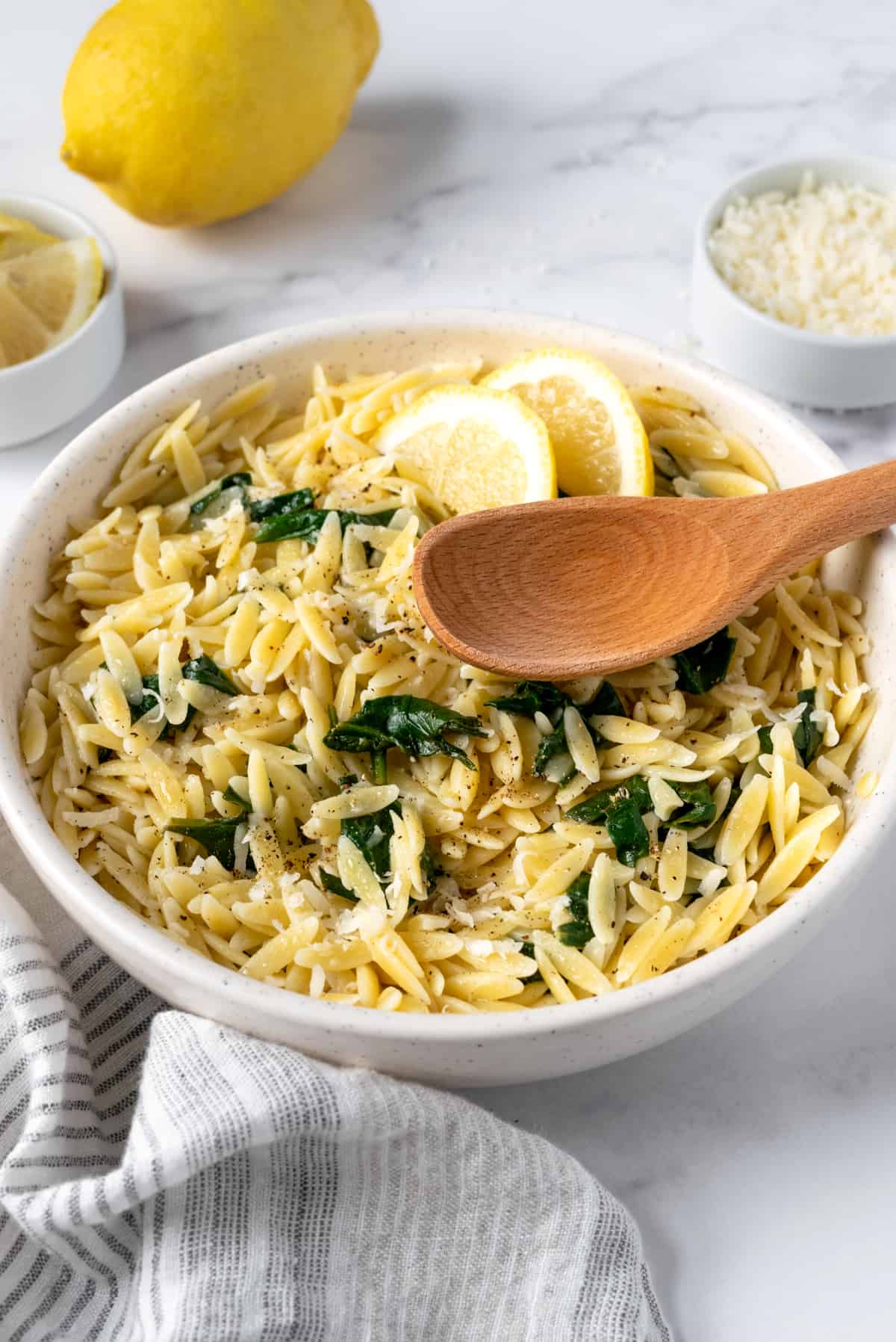 Lemon Orzo with Spinach with parmesan cheese and lemon slices.