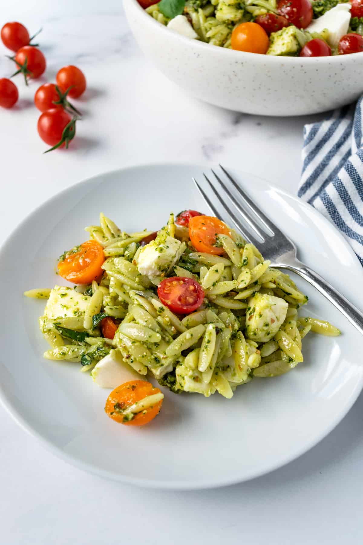 Pesto Orzo Salad on a white plate with a fork.