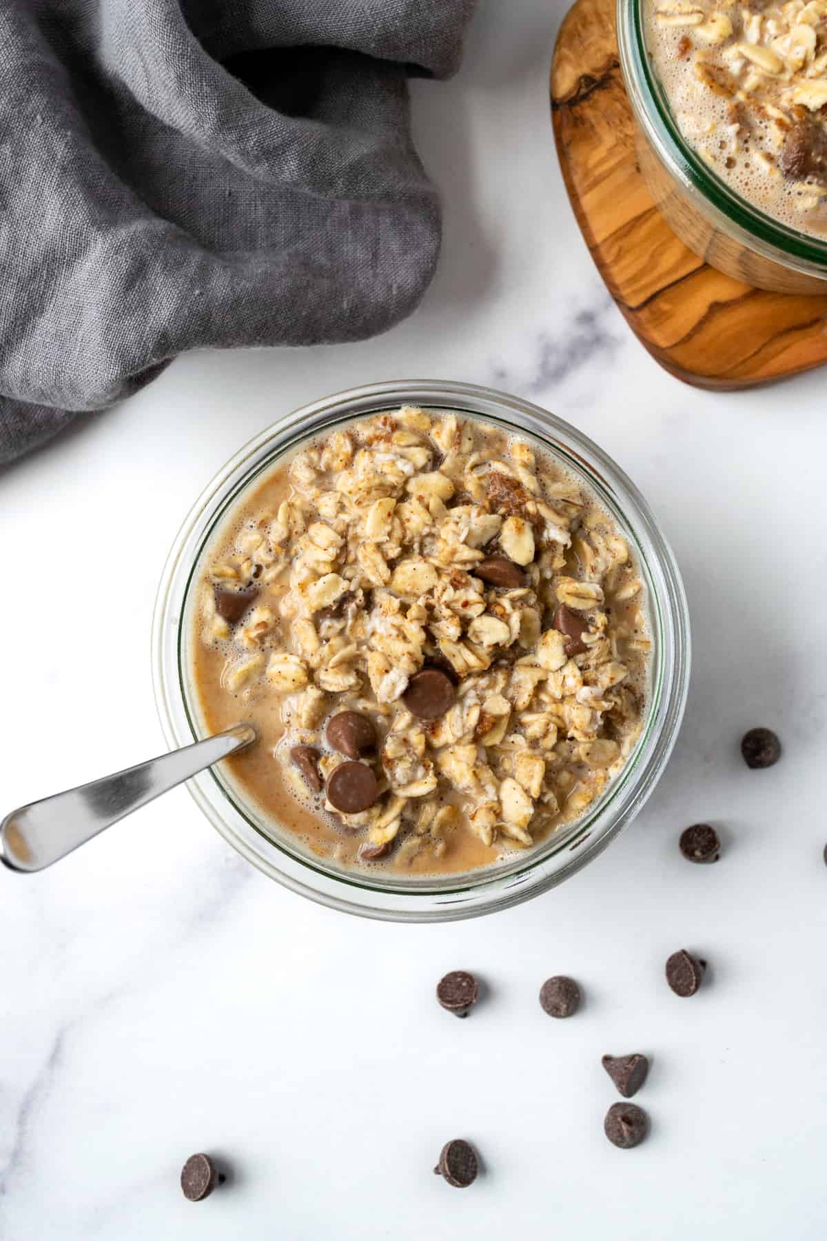 Cookie Dough Overnight Oats in a glass jar with a spoon.