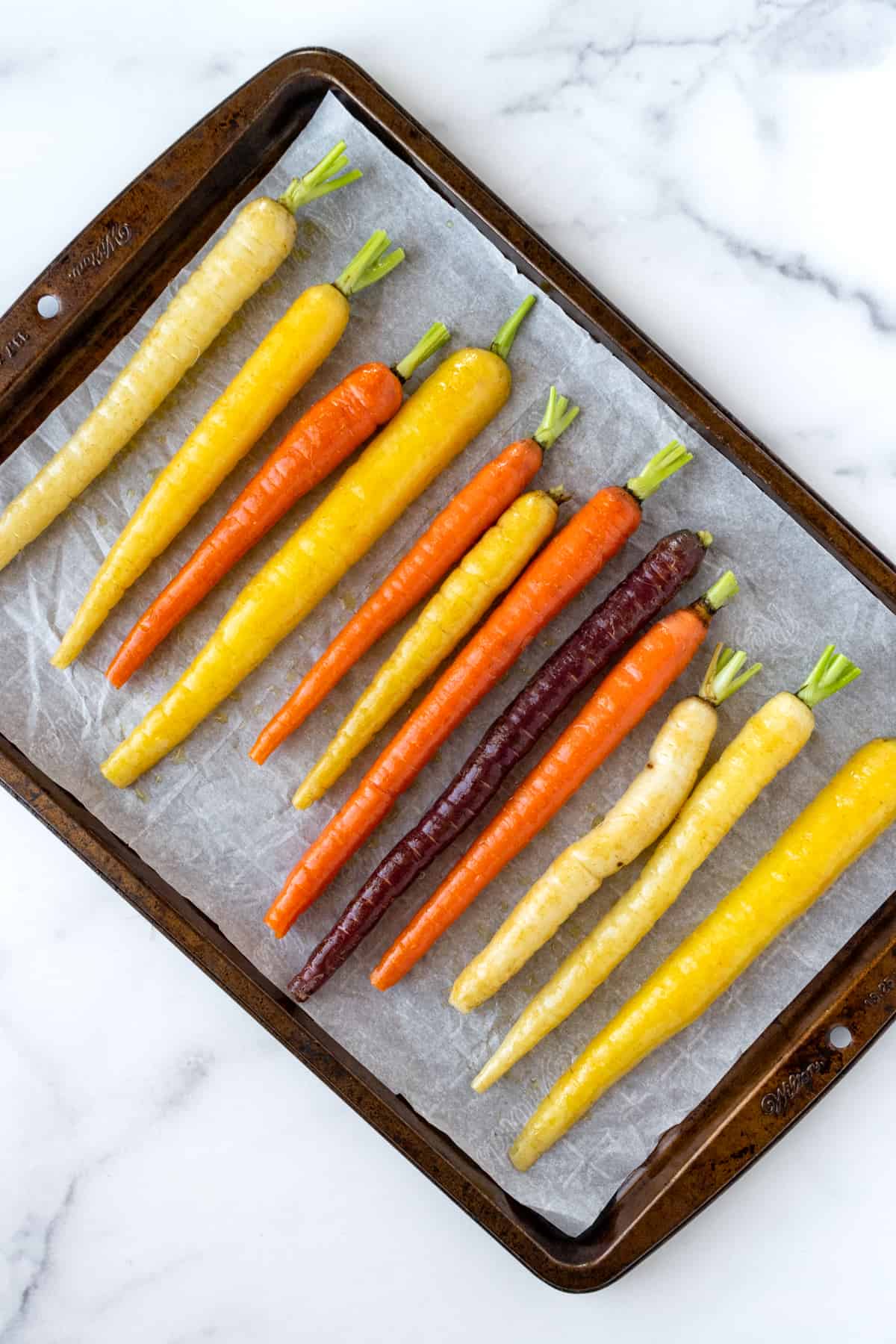 Rainbow Carrots on a parchment lined baking sheet