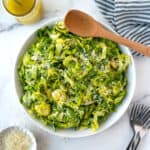 Parmesan Brussels Sprouts Salad in a serving bowl with a wooden spoon.