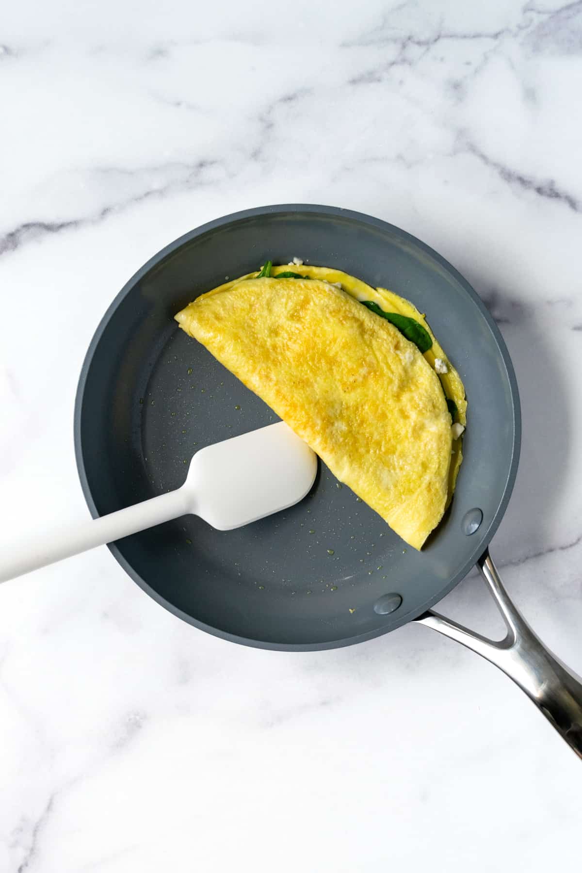 Spinach and Feta Omelette in non-stick pan.