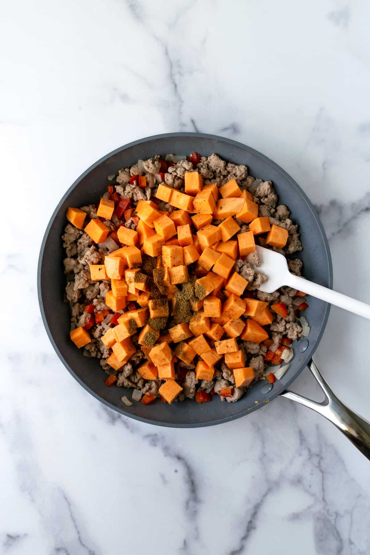 Sautéing Turkey Hash with Sweet Potatoes in a skillet.