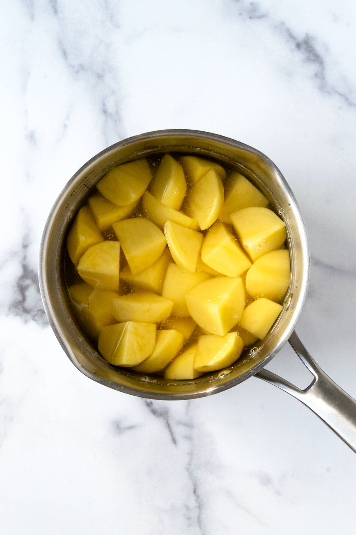Chopped potatoes in a pot of water.