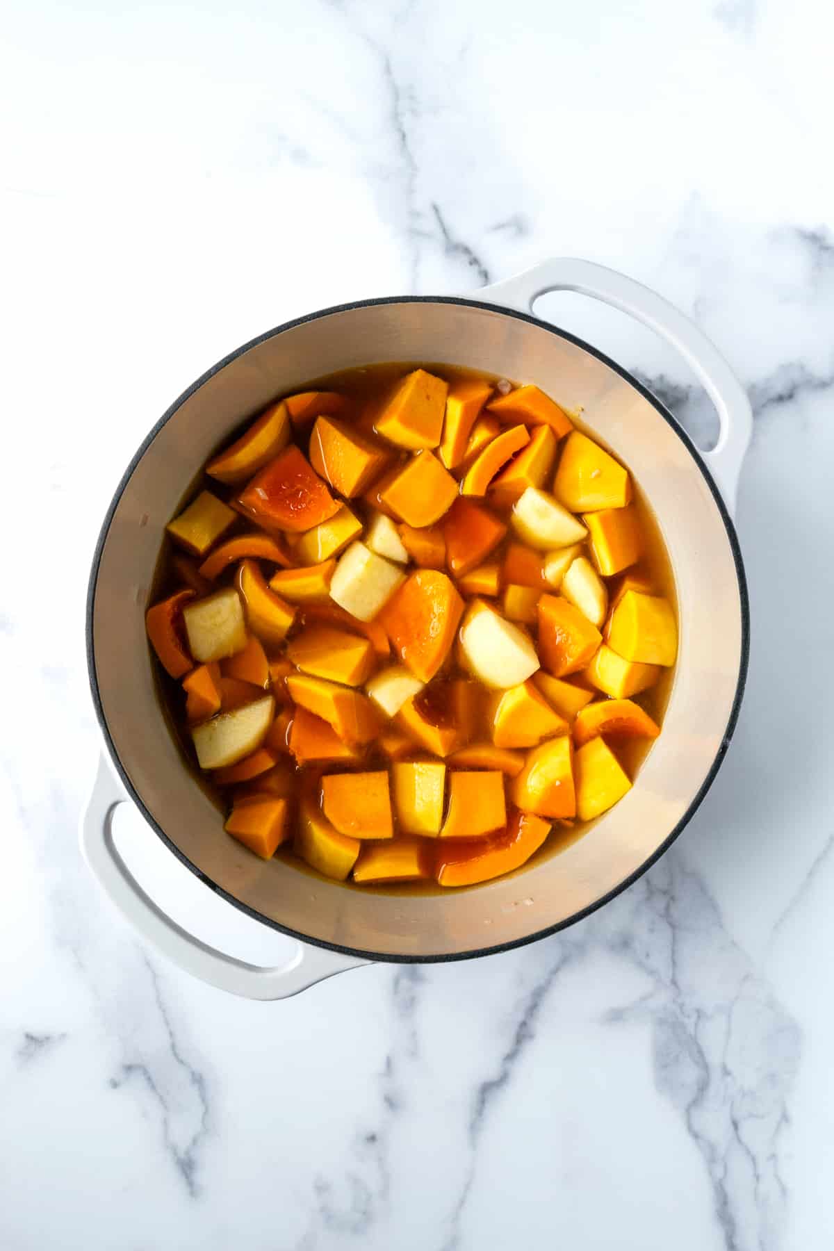 Making Honeynut Squash Soup in a large white pot.