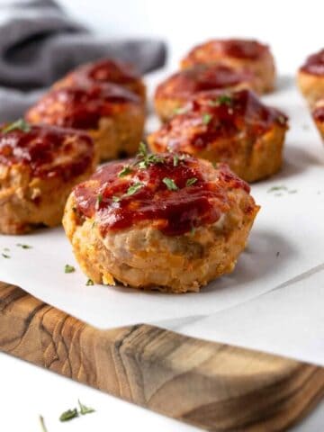 Turkey Meatloaf Muffins on a wood cutting board with parchment paper.