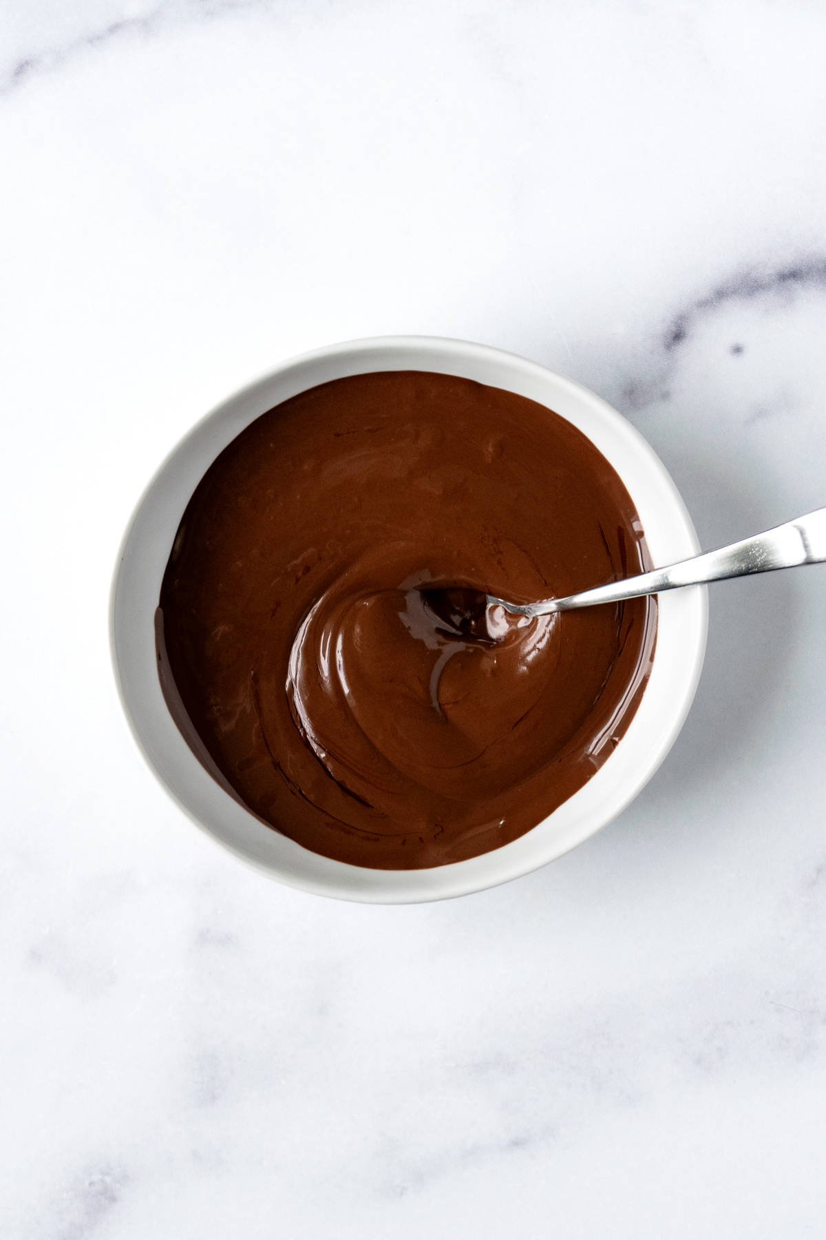 A white bowl of melted chocolate.
