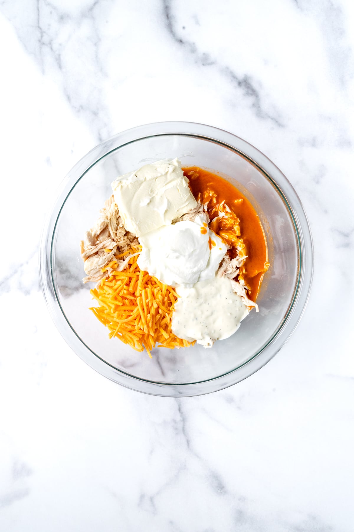 Greek Yogurt Buffalo Chicken Dip Ingredients in a Glass Mixing Bowl.