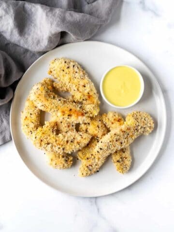 Everything Bagel Chicken Tenders on a White Plate with Honey Mustard Dipping Sauce.
