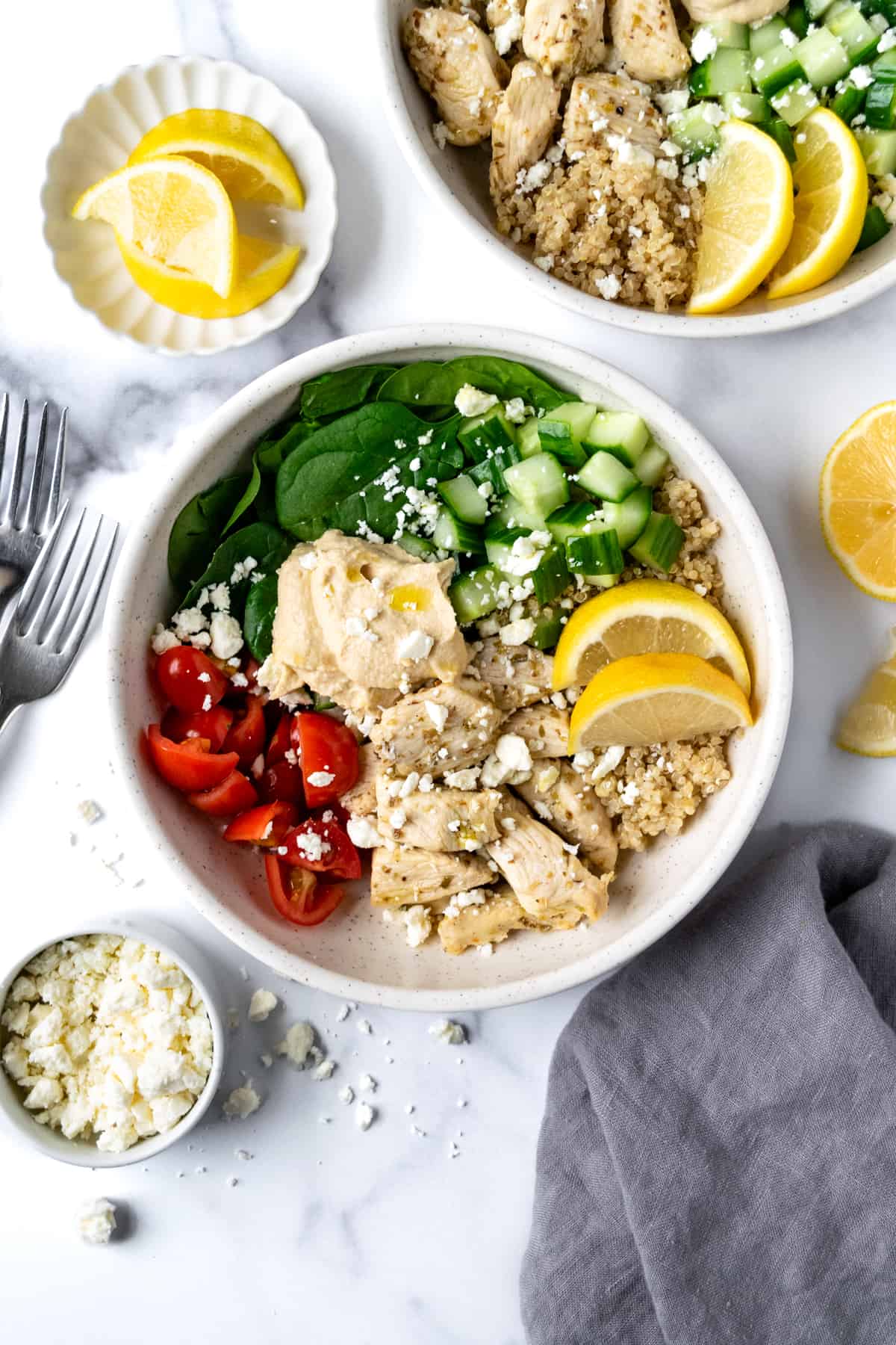 Mediterranean Power Bowls on a marble countertop with lemon wedges.
