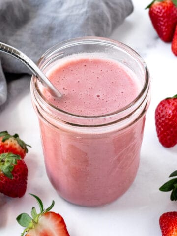 Almond Milk Strawberry Smoothie in a glass on a counter.