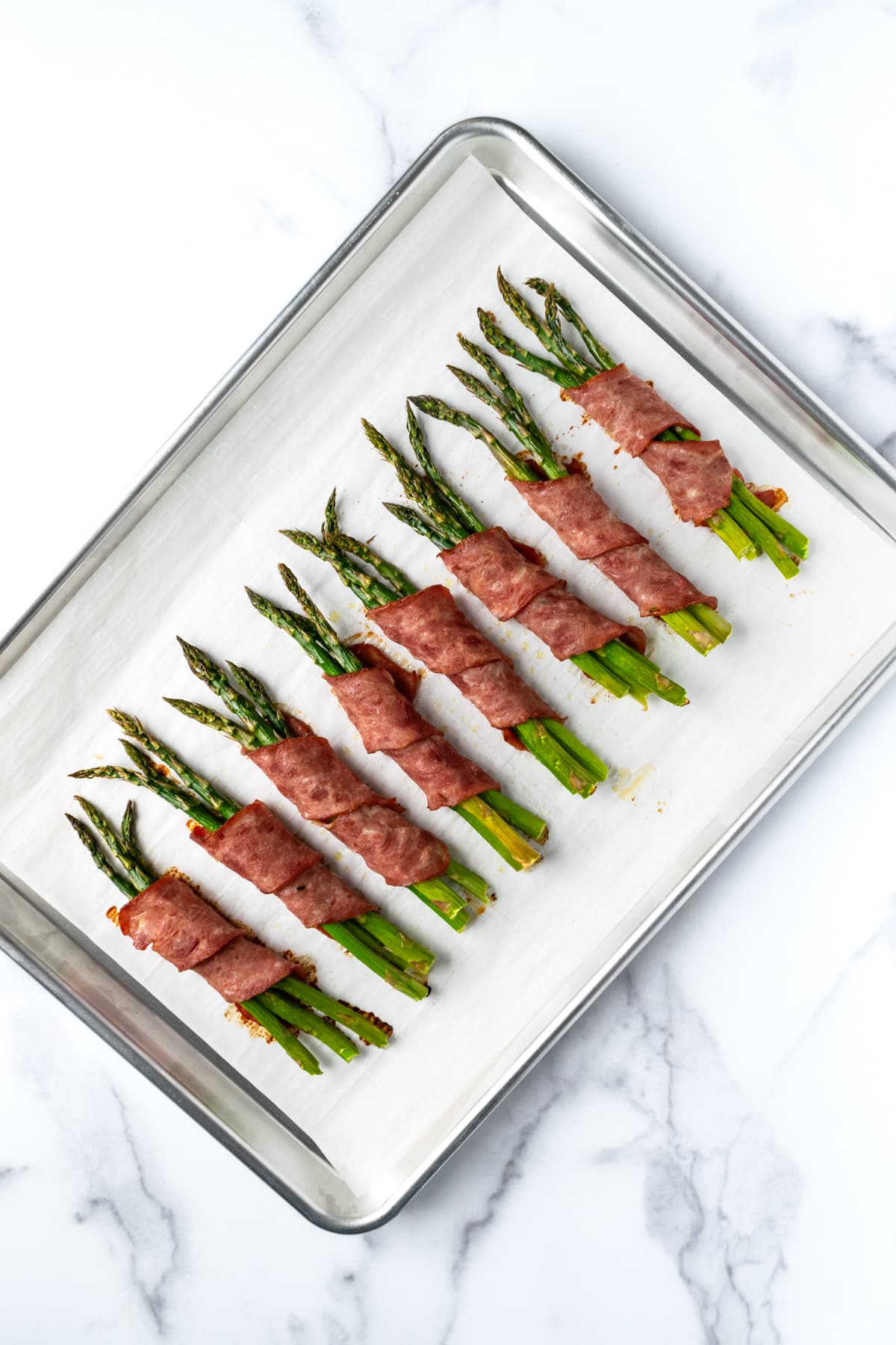 Turkey Bacon Wrapped Asparagus Bundles on a baking sheet.