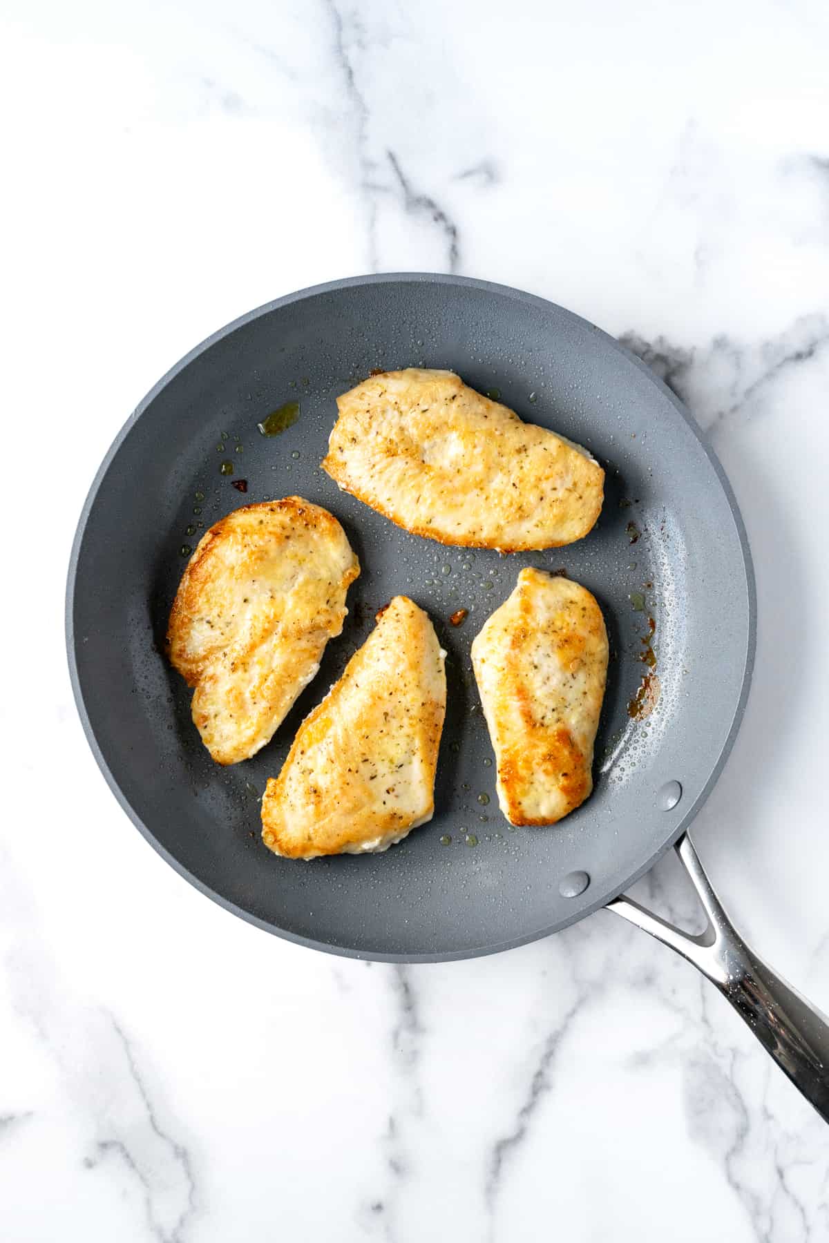 Cooked Chicken Cutlets in a Skillet.