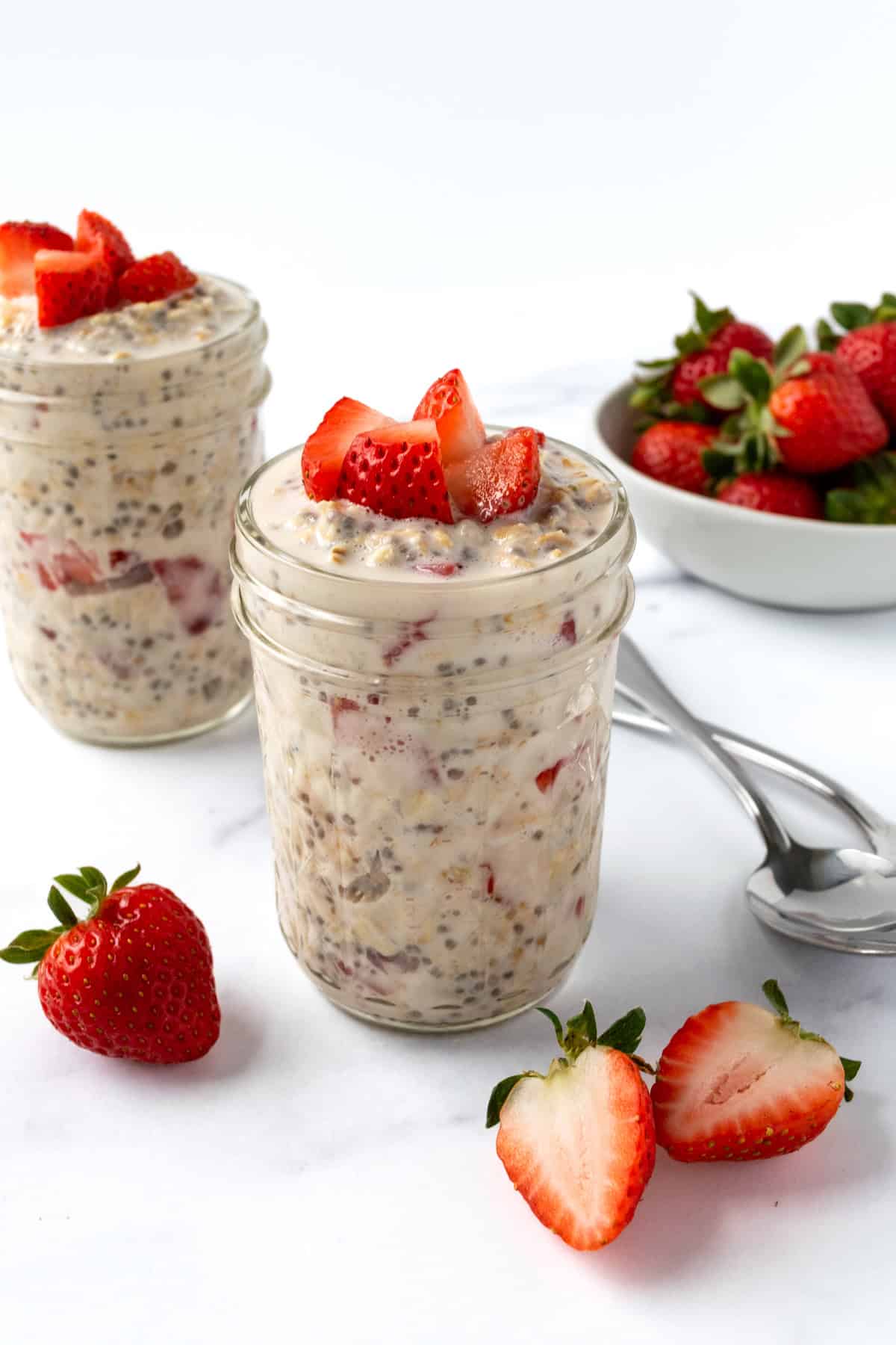 Strawberries and Cream Overnight Oats on a marble counter with a spoon.