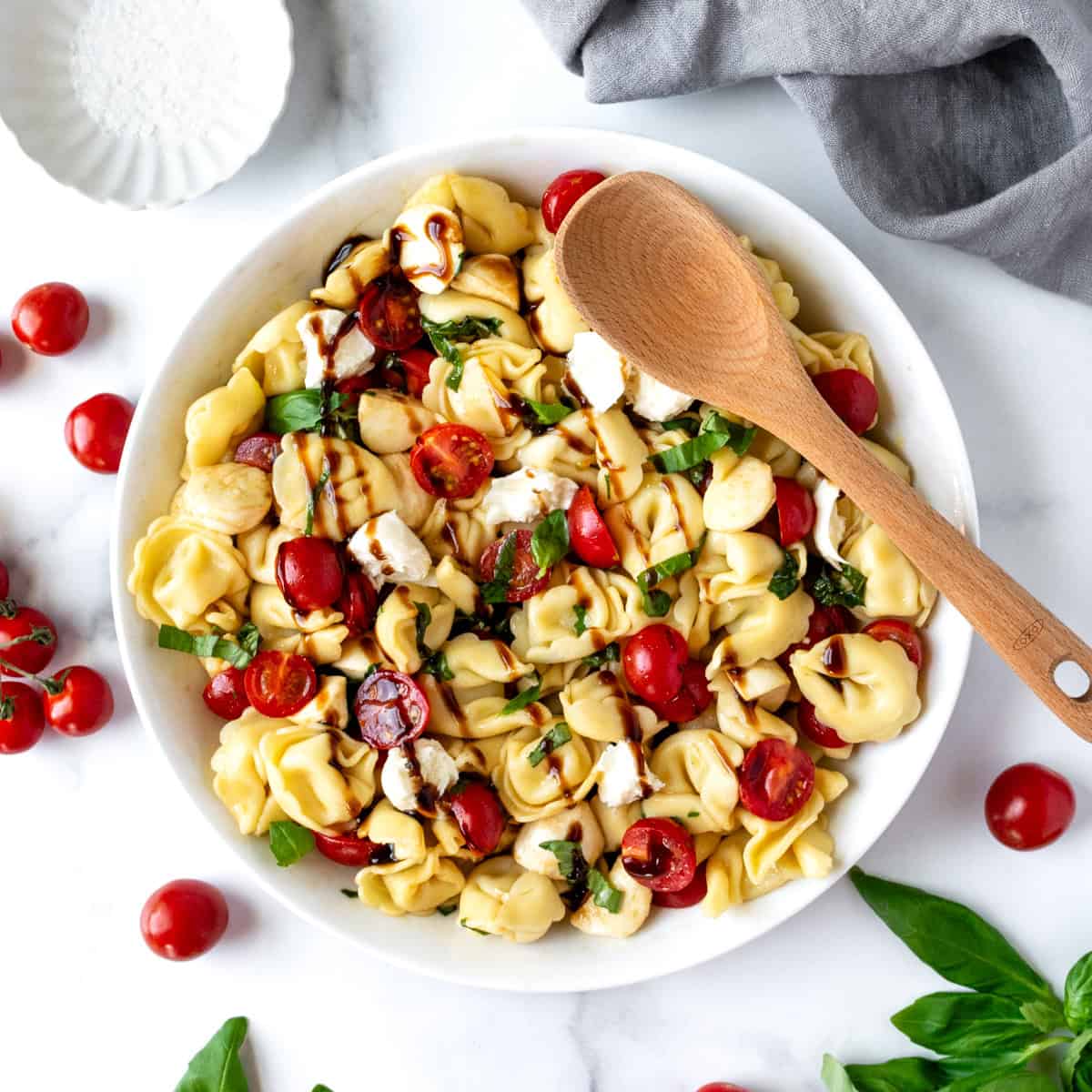 Caprese Tortellini Salad in a serving bowl with a spoon.