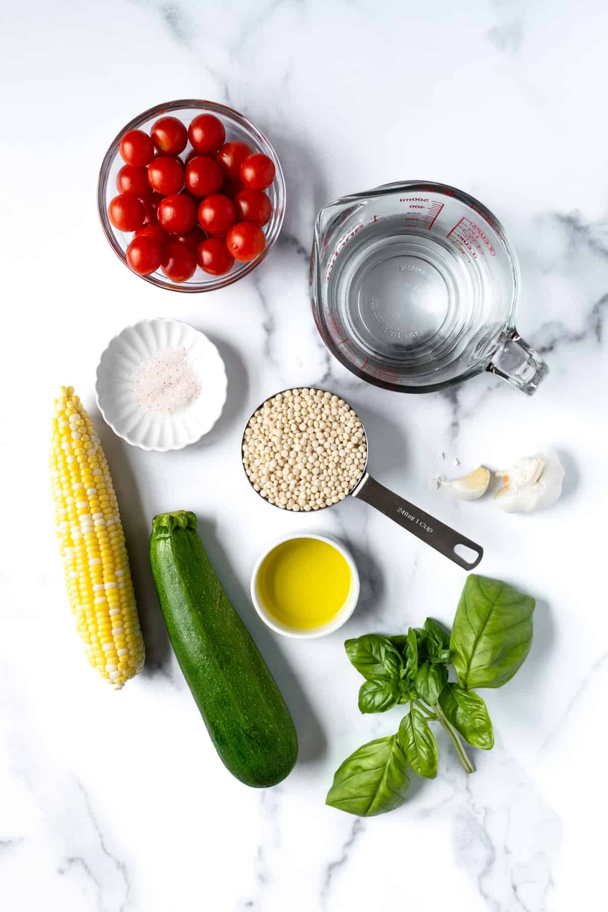 Summer Pearl Couscous Ingredients on a marble countertop.