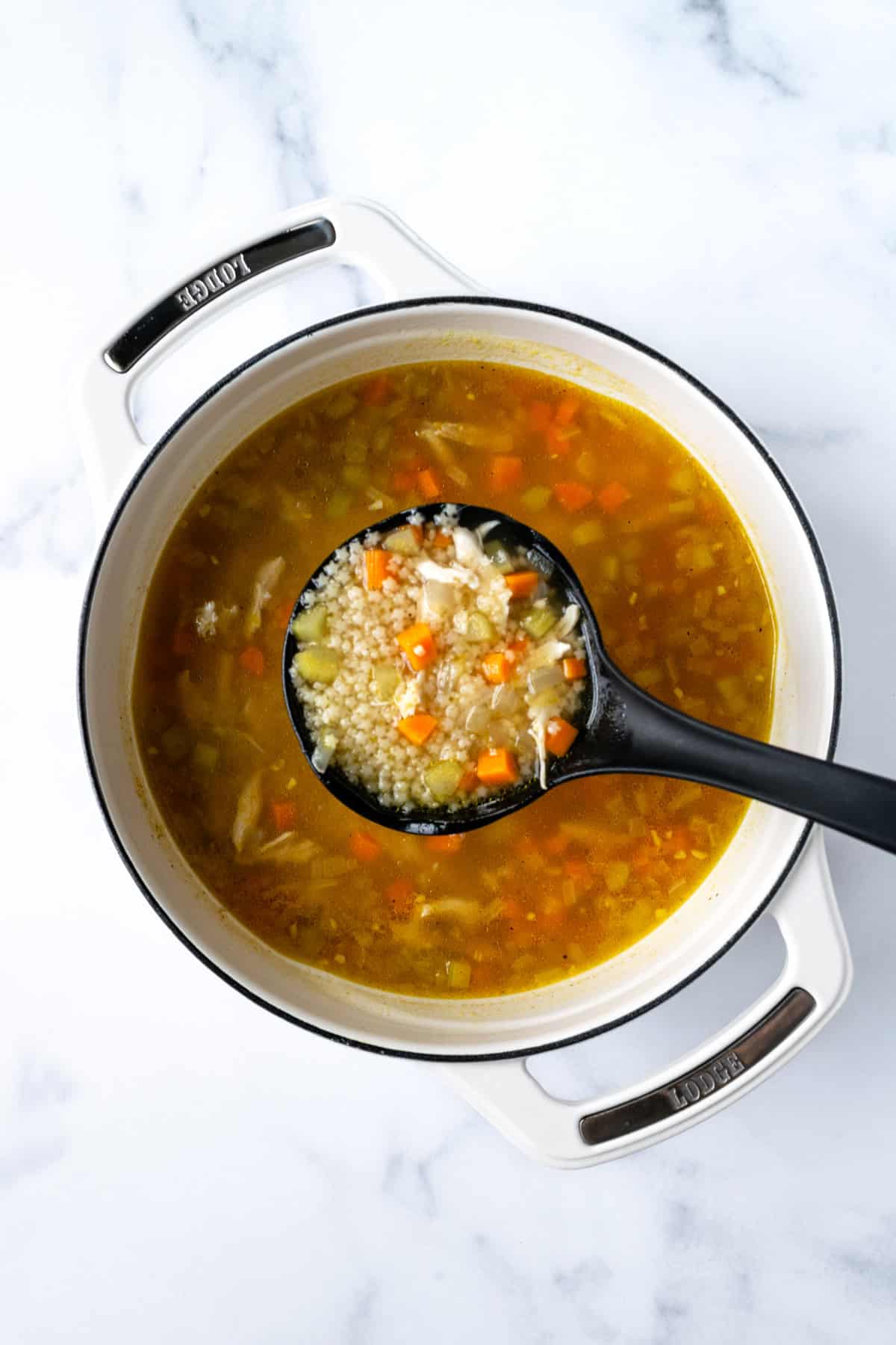 Ladle full of Chicken Pastina Soup.