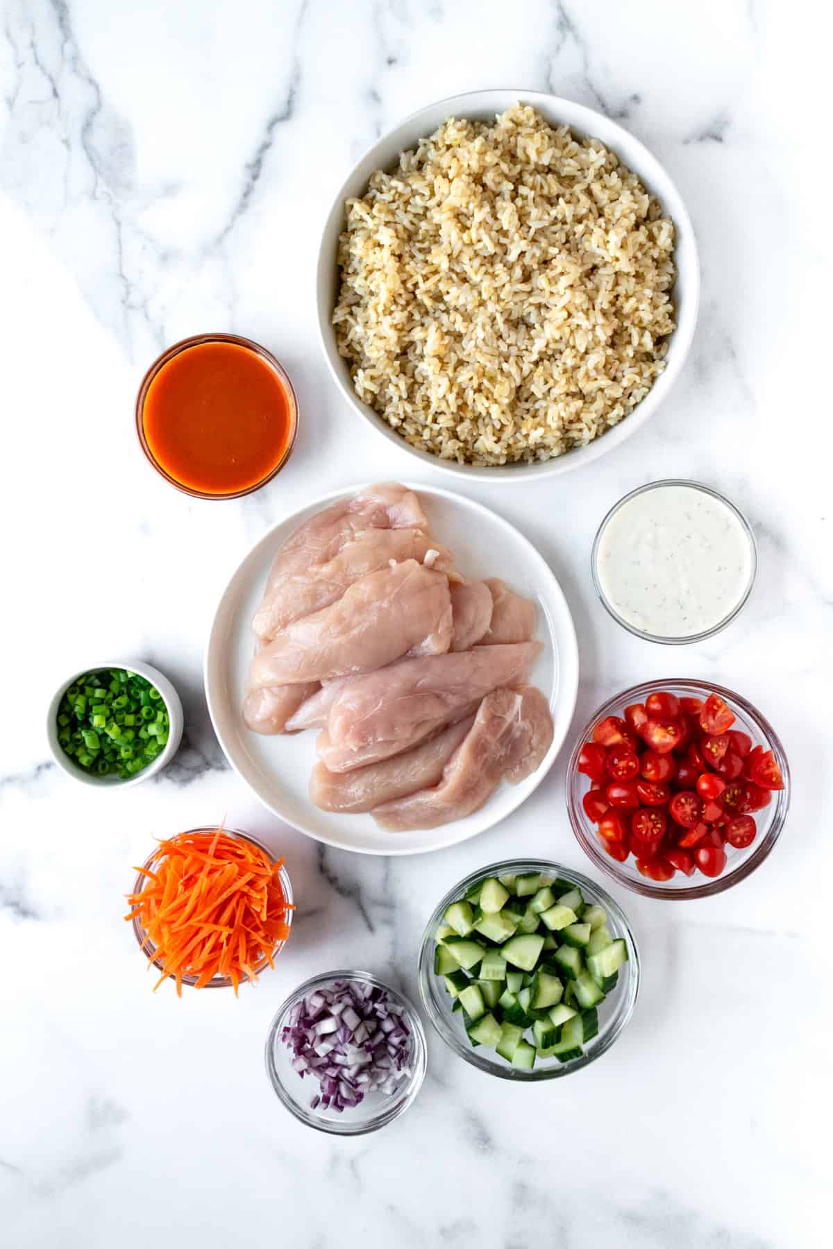 Buffalo Chicken Rice Bowls Ingredients on a marble countertop.
