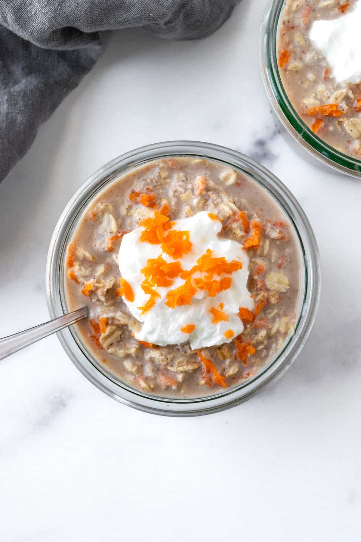 Carrot Cake Overnight Oats topped with greek yogurt and grated carrots.
