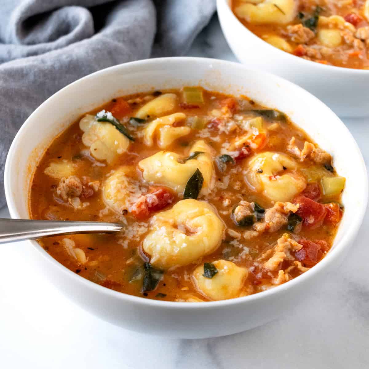 Chicken Sausage Tortellini Soup in a white bowl.