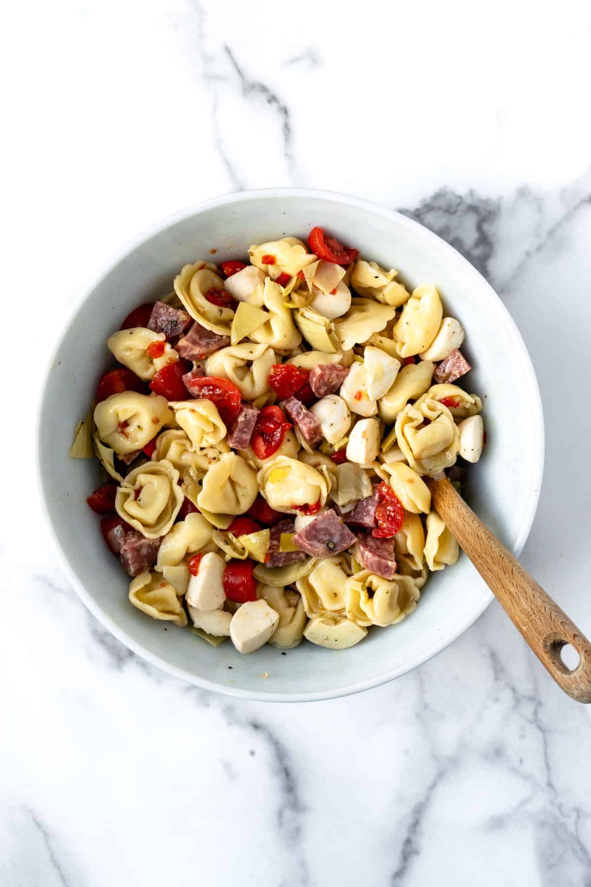 Antipasto Tortellini Salad mixed in a white bowl.
