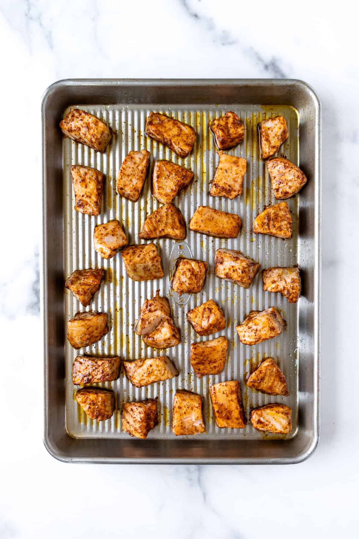 Taco Seasoned Salmon Chunks on a Baking Sheet.
