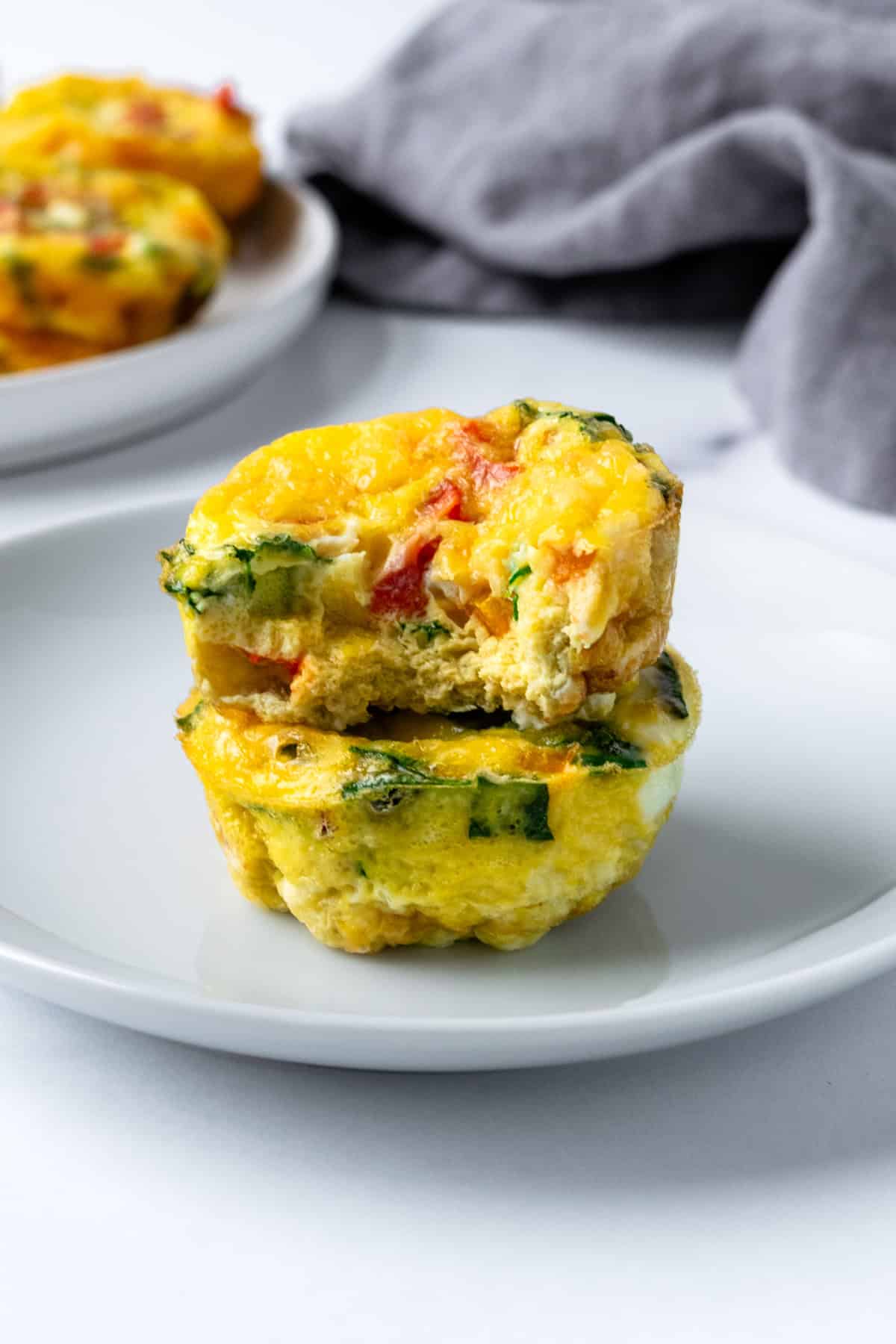 Two Egg bites stacked with one missing a bite.