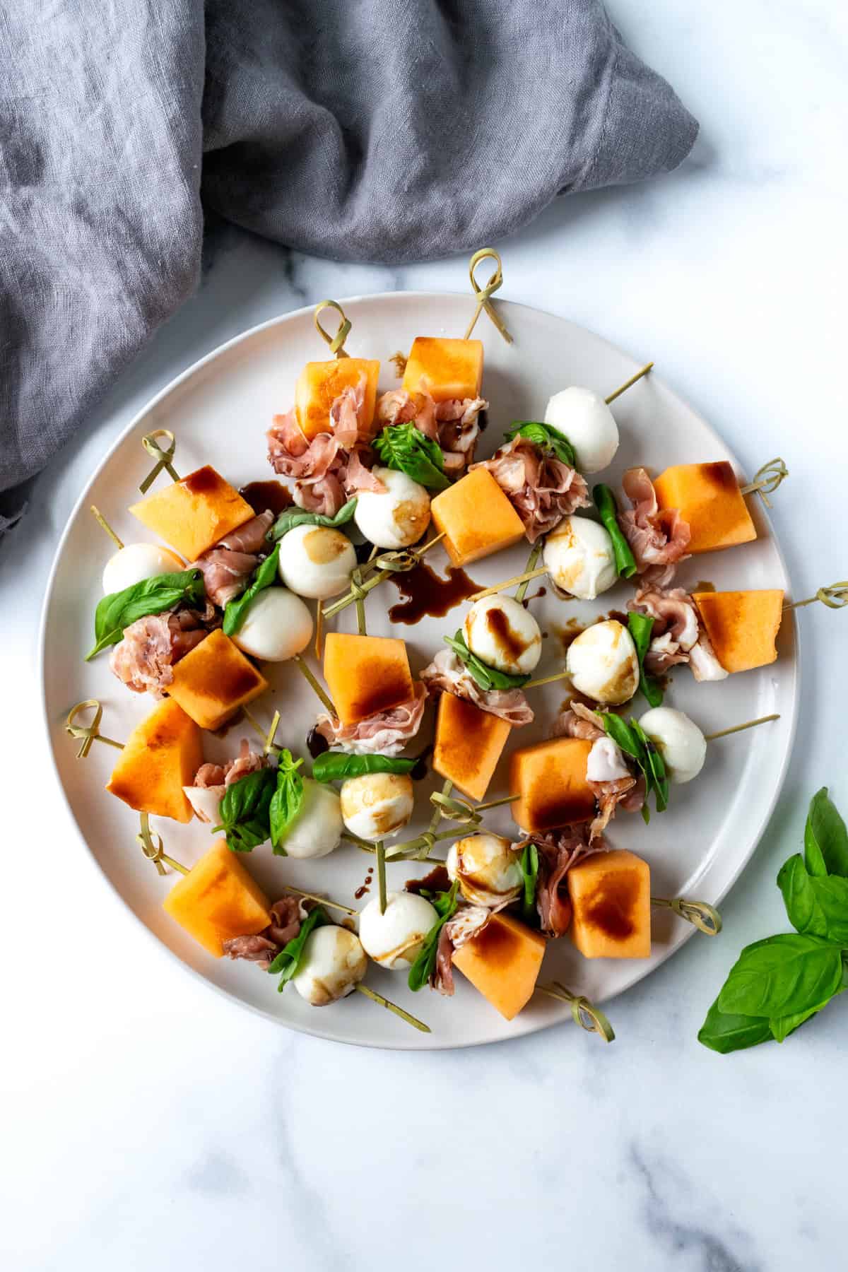 Cantaloupe Appetizer Skewers on a white plate.