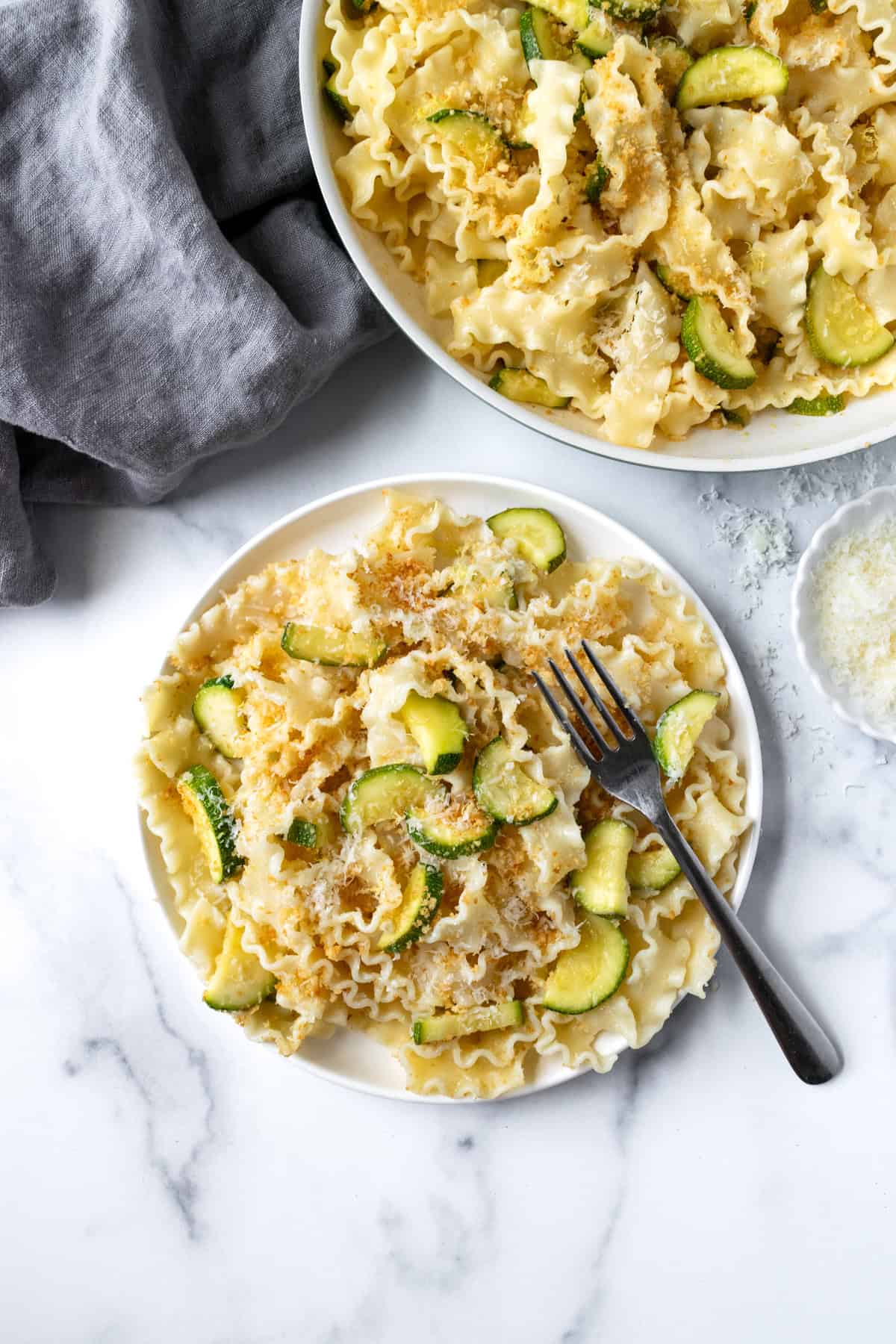 Lemon Zucchini Pasta on a white plate with a fork.