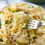 Lemon Zucchini Pasta on a white plate with a fork.