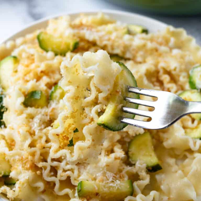 Lemon Zucchini Pasta on a white plate with a fork.