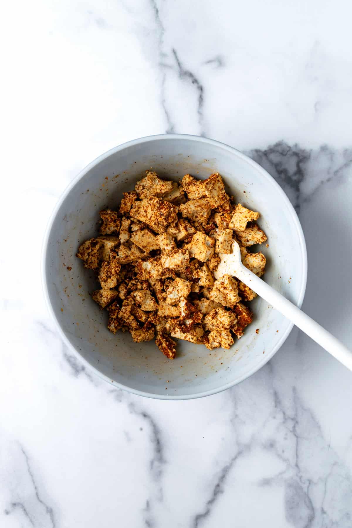 Tofu chunks with taco seasoning in a bowl.