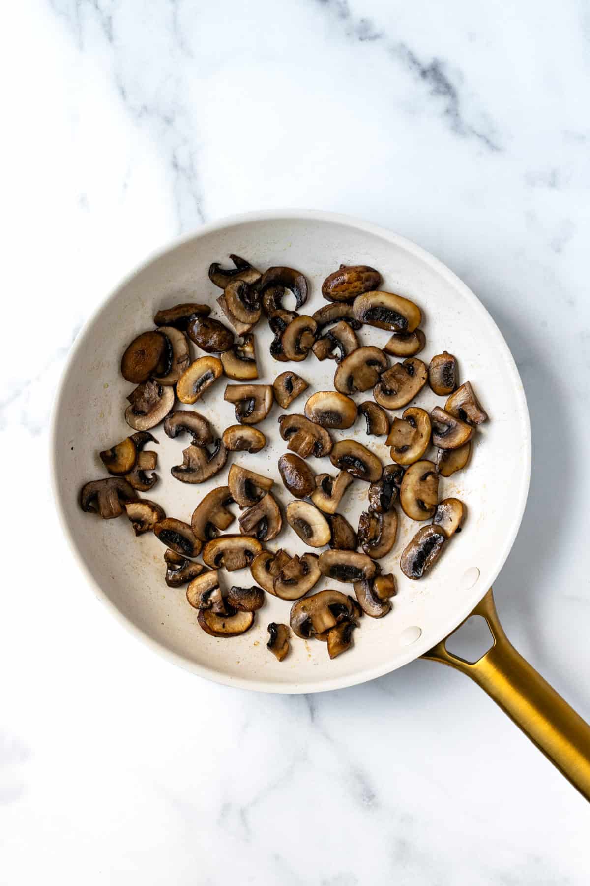 Sautéed Mushrooms in a white skillet.