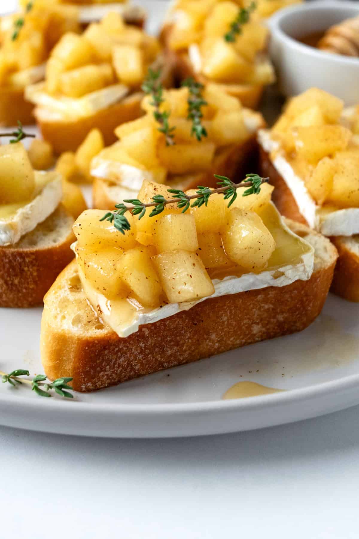 Apple and Brie Crostini on a white plate.