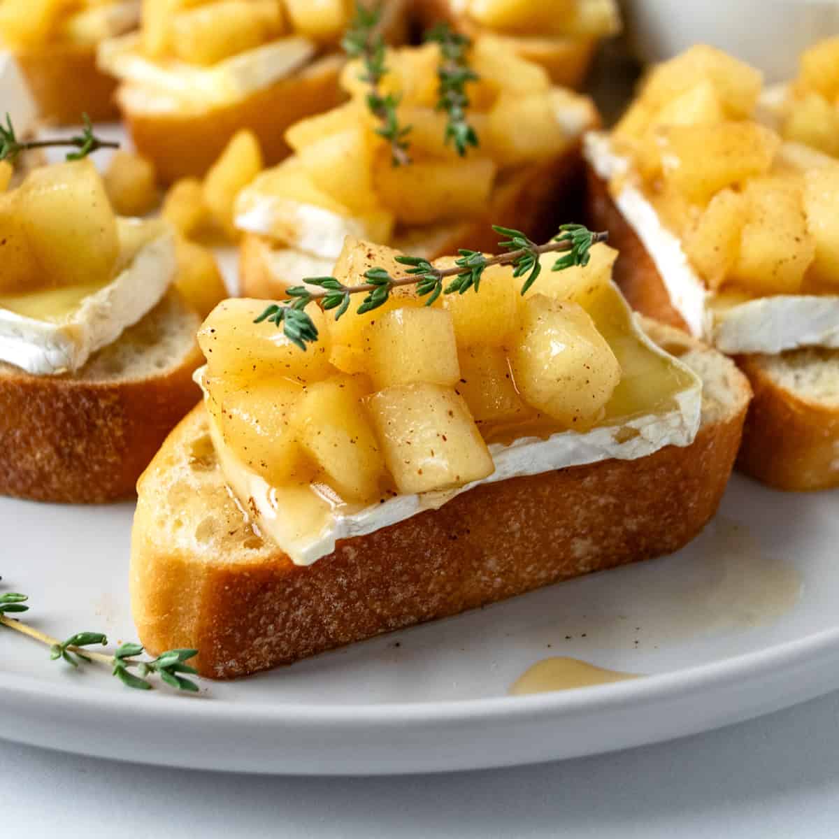 Apple and Brie Crostini on a white plate.