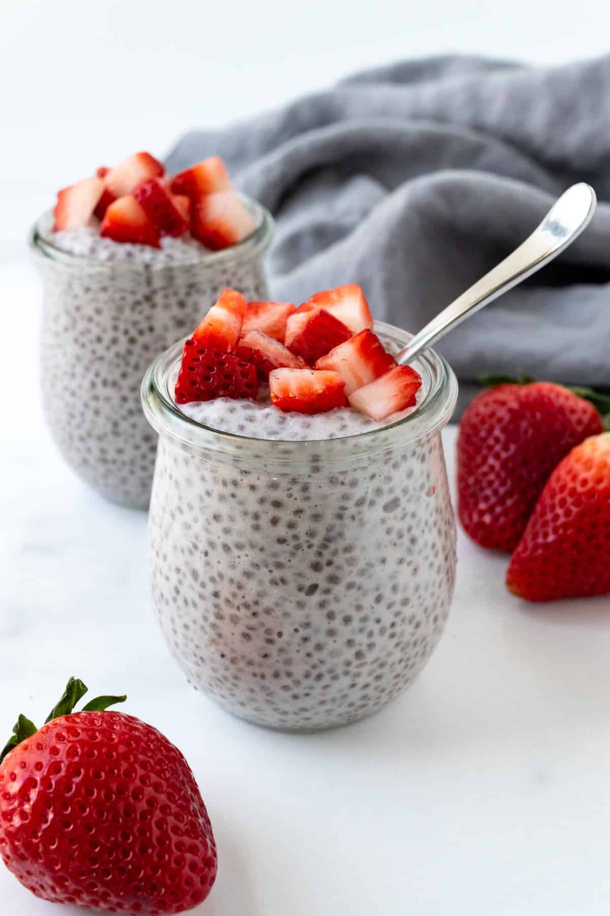 Strawberry Chia Pudding in a glass jar with a spoon.
