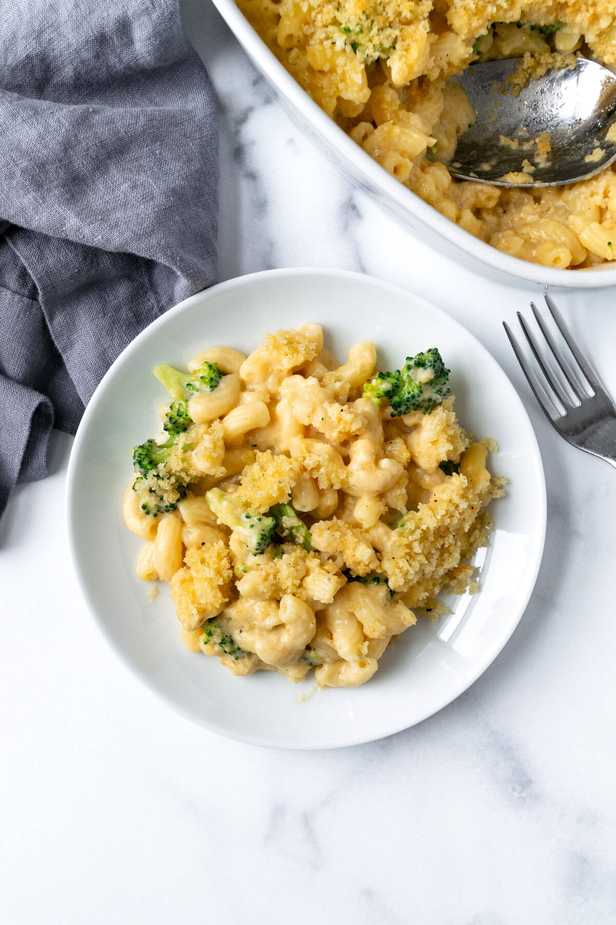 Baked Broccoli Mac and Cheese topped with Breadcrumbs on a white plate.