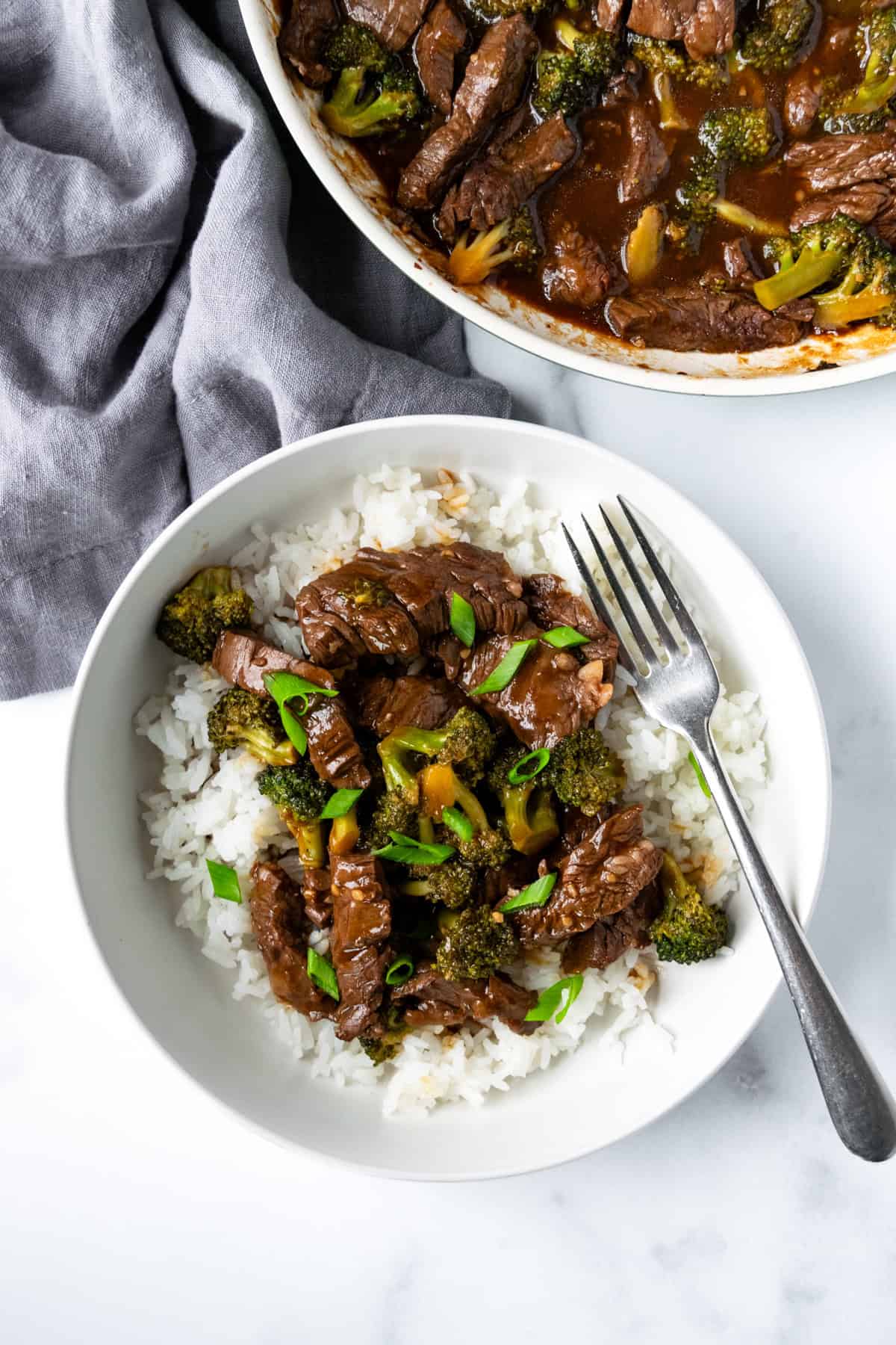 Beef and Broccoli Bowl on a table with the skillet of it.