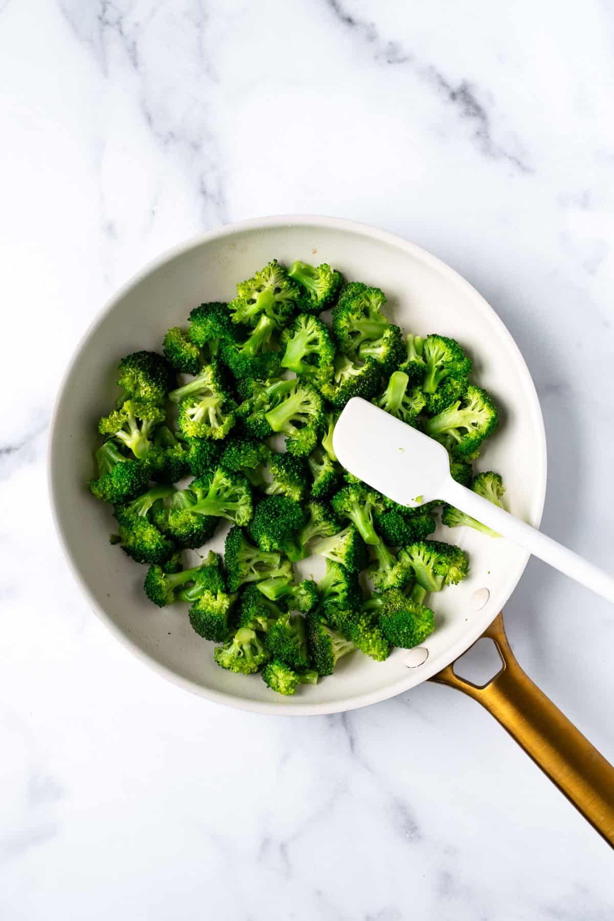 Sautéed Broccoli in a white skillet.