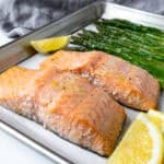 Sheet Pan Salmon and Asparagus on a baking sheet with lemon wedges.