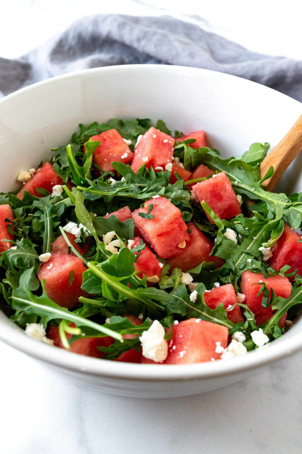 Watermelon Salad with Arugula and Feta in a white bowl.