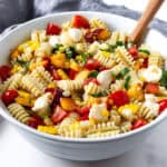 Peach and Corn Pasta Salad in a white bowl.