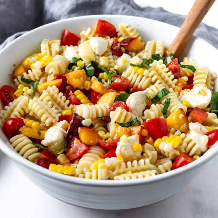 Peach and Corn Pasta Salad in a white bowl.