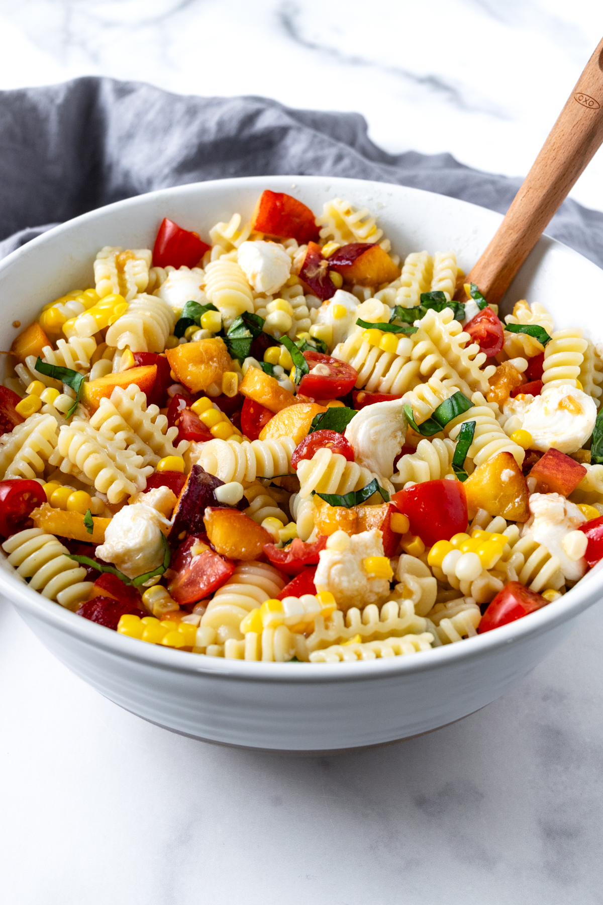 Peach and Corn Pasta Salad in a white bowl.